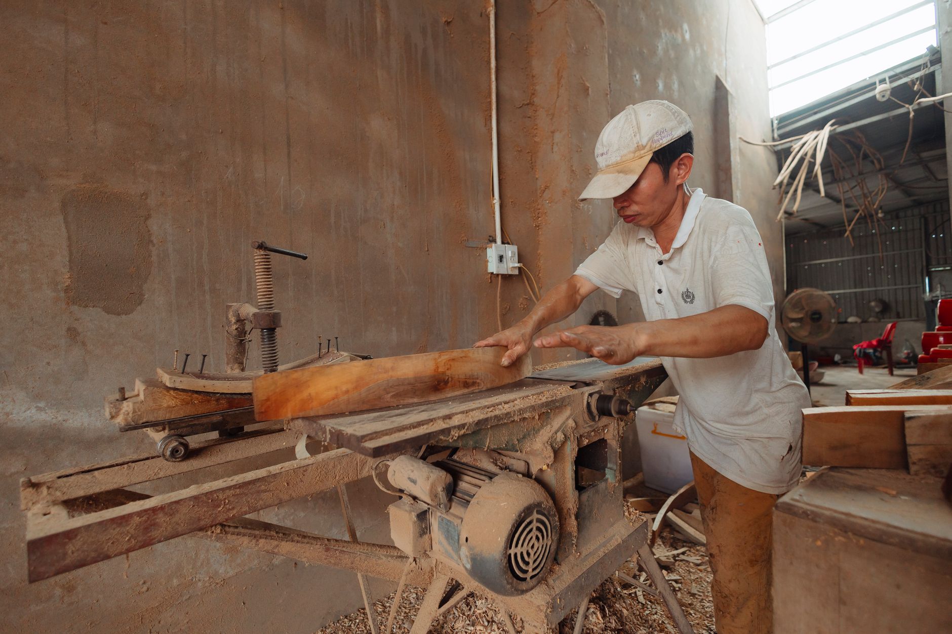 Menuisier qui coupe du bois avec précision dans son atelier, image illustrant un artisan qui veut passer devant ses concurrents sur Google